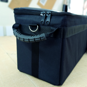 Black solid side padded bag showing a ring to attach shoulder strap.